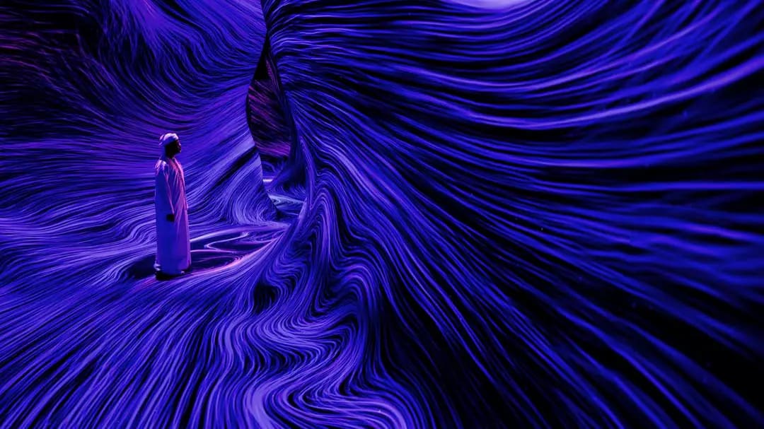Відвідувач серед плинних фіолетових ліній світла в teamLab Phenomena Abu Dhabi